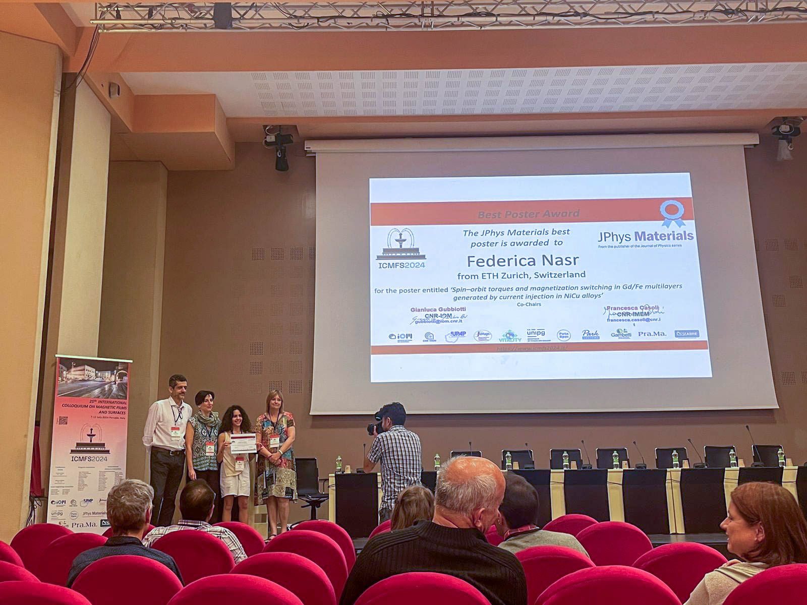 Federica Nasr as she receives her prize in the bottom left.